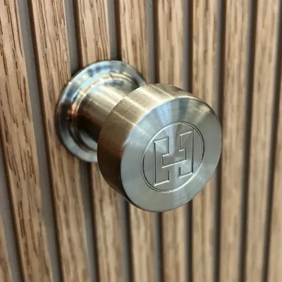 Hassel&Teudt HKN01L - Møbelhåndtak med H&T-logo, PVD-børstet stål